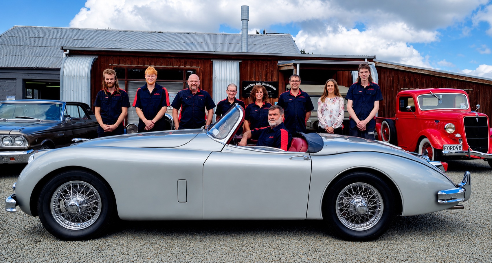 The Geraldine Auto Restorations team with a restored classic convertible
