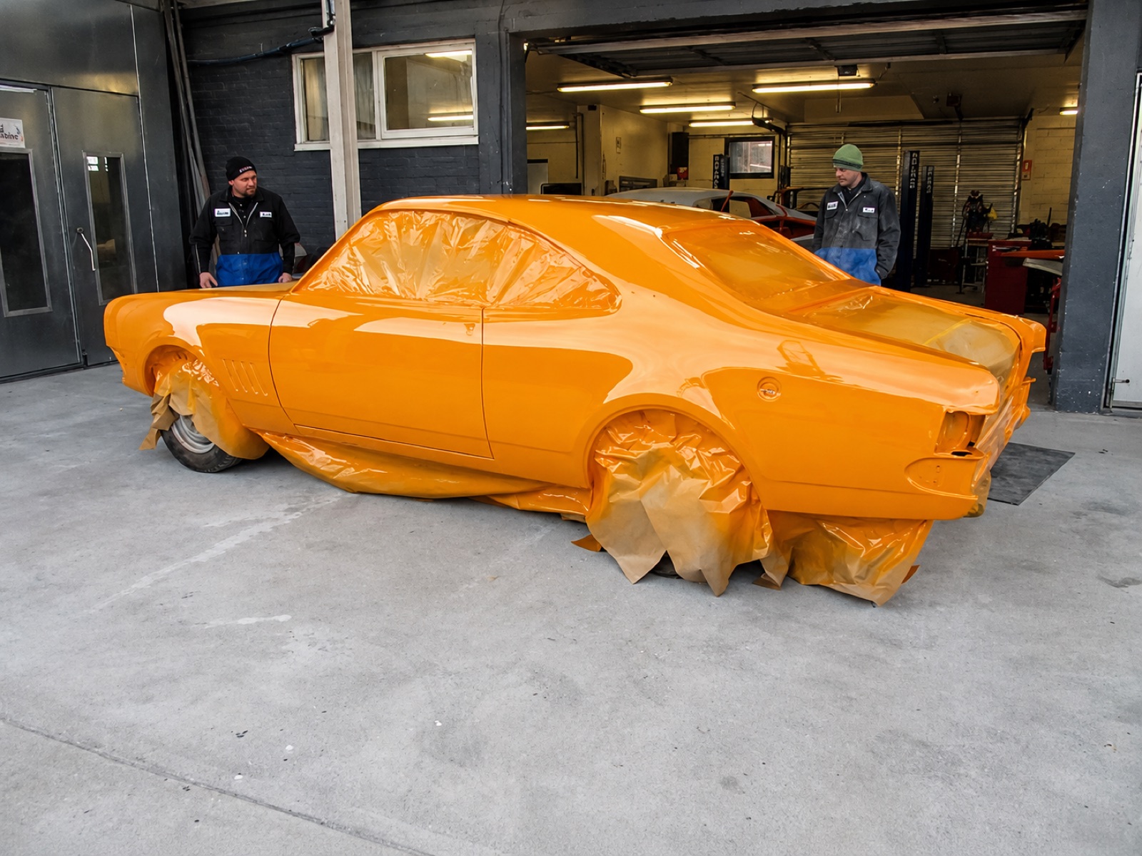 Custom orange sports car body in primer during fabrication