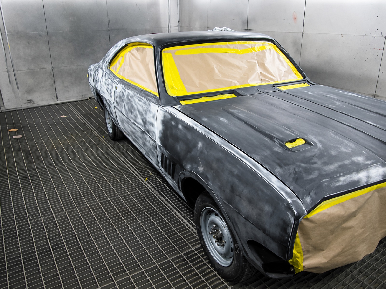 Classic car masked up in the spray booth ready for painting