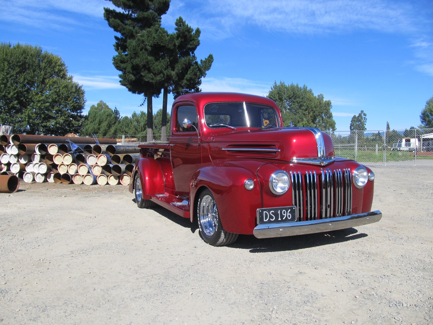 The finished candy red Ford pickup on chrome wheels