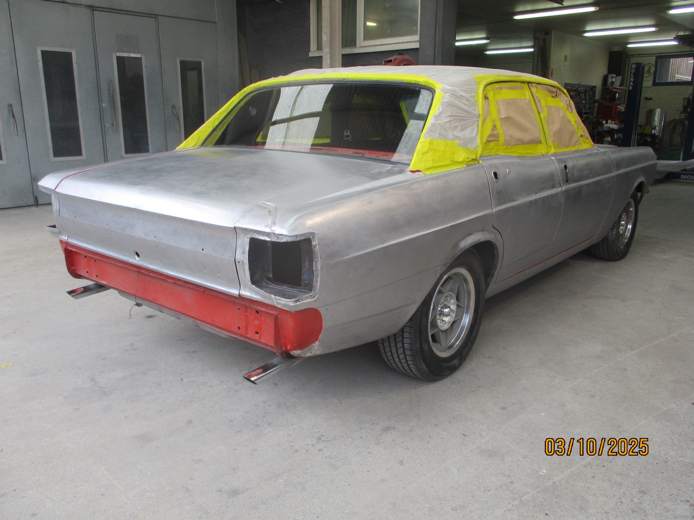The Falcon in bare metal and primer inside the paint booth